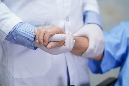 Close up of a physician holding onto a patient's arm