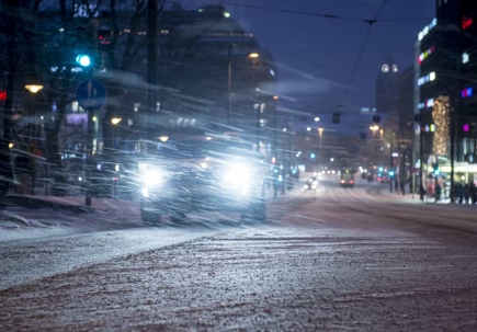Car with blue headlights driving on an urban snowy road at night | Gaddis, Herd, Craw & Adams, P.C.