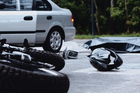 motorcycle and helmet on floor after crashing into a car