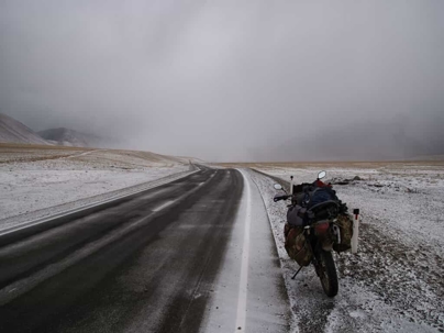 motorcycle sitting on the side of a road covered with snow