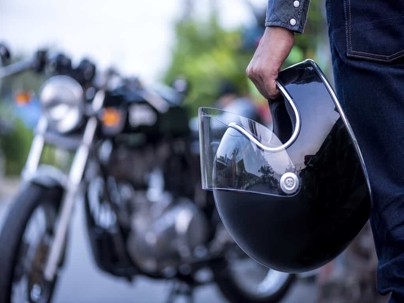 motorcyclist holding helmet
