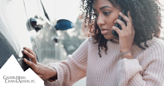 woman checking damage on vehicle